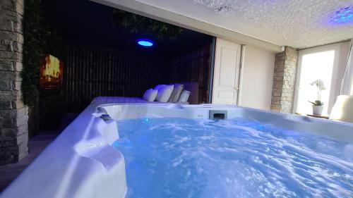 a bath tub filled with blue water in a room at Love room le bain in Le Val