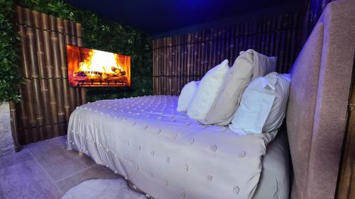 a bedroom with a bed with pillows and a fireplace at Love room le bain in Le Val