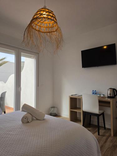a bedroom with a bed and a desk and a television at HOSTAL CASA EMILIO in Almería