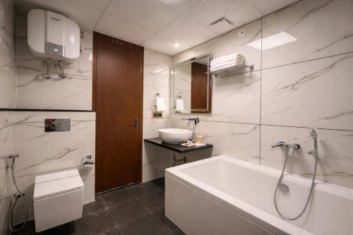 a bathroom with a bath tub and a sink at RLS Hotels, Greater Noida Near Expo Centre & Mart in Greater Noida