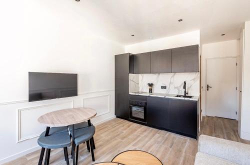 a living room with a table and a kitchen at La Belle Echappée - Superbe T2 en Hyper Centre in Thonon-les-Bains