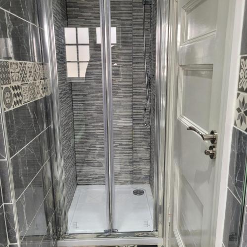 a shower with a glass door in a bathroom at Luxury 6 bed house by the sea in Rhos-on-Sea