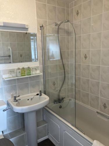a bathroom with a sink and a shower and a tub at Seaview Sanctuary in Eastbourne
