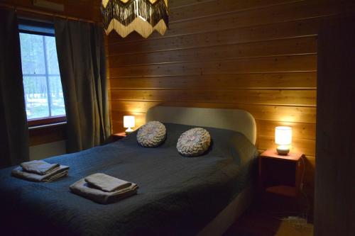 a bedroom with a bed with two towels on it at Poropelto Cottage in Ruhtinaansalmi