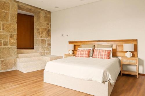 a bedroom with a large bed and a stone wall at Quinta de Travanca - Casa do Páteo, Baião, Douro in Baião