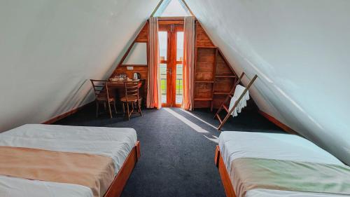 a room with two beds and a table in a attic at Villa Evermist in Nuwara Eliya
