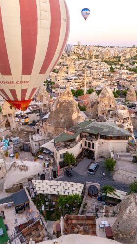 two hot air balloons flying over a city at Ascension Cave Suites - Special Class in Göreme