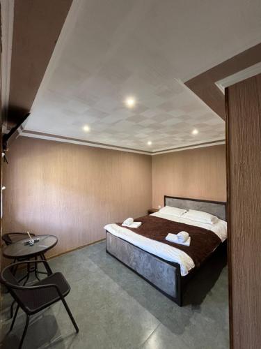 a bedroom with a large bed and a table at Paulownia Garden in Mtskheta