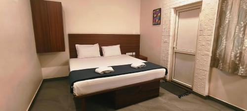 a bedroom with a bed with two towels on it at Avea Accommodation in Madurai
