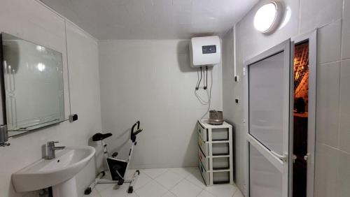 a white bathroom with a sink and a shower at Momo's villa 2nd room in Aït Ourir