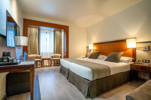 ein Hotelzimmer mit Bett und Schreibtisch in der Unterkunft Hotel Balmoral in Barcelona