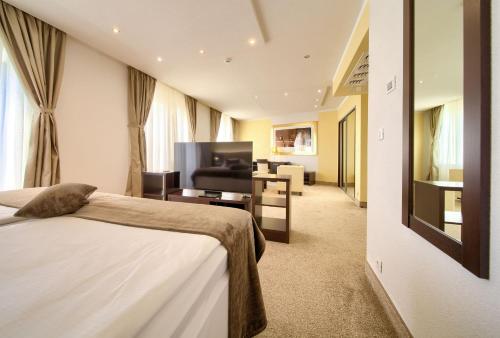 a hotel room with a bed and a living room at Hotel Marina in Krk