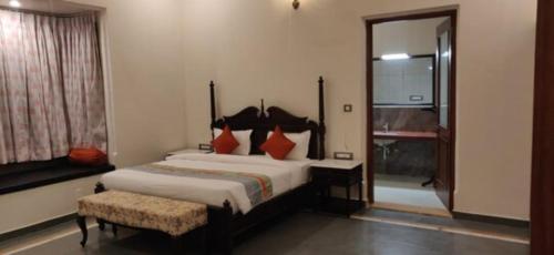 a bedroom with a bed and a chair and a window at Tej Gadh Jambuda in Sālūmbar