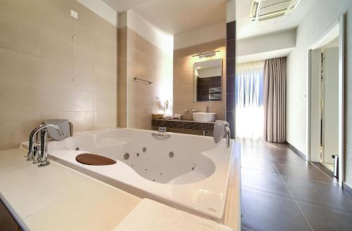 a large white bathroom with a large bath tub at Hotel Marina in Krk