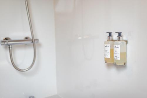 a bathroom with a shower with two bottles on the wall at Quarme Cottage Wheddon Cross in Wheddon Cross