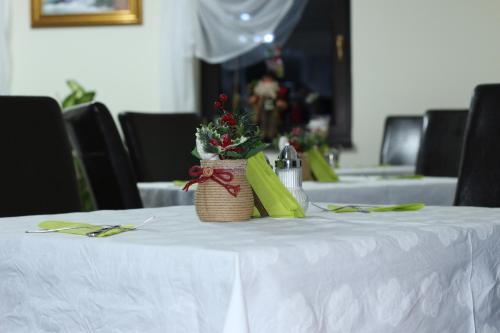 a table with a white table cloth and a basket of flowers at Amso Residence in Sibiu