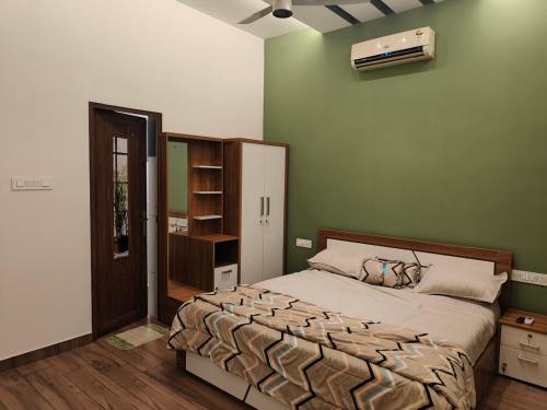a bedroom with a bed and a green wall at The Riverside Nook Calicut in Kozhikode