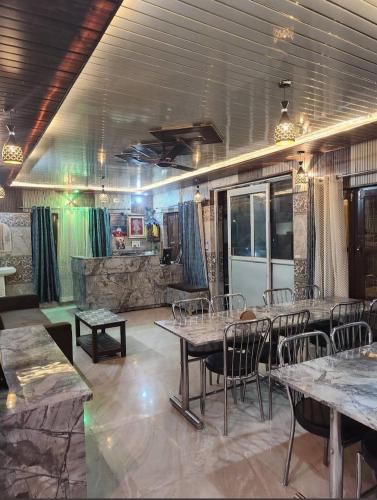 a restaurant with tables and chairs in a room at Hotel Khetan Residency Yamunotri Dham in Kharsālī