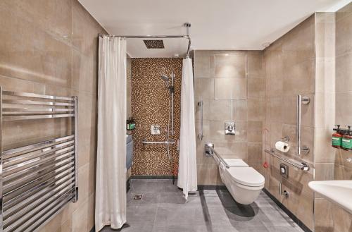a bathroom with a toilet and a shower and a sink at Hyatt Regency London Albert Embankment in London