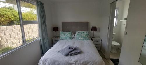 a bedroom with a bed with two towels on it at Drommedaris in Gordonʼs Bay