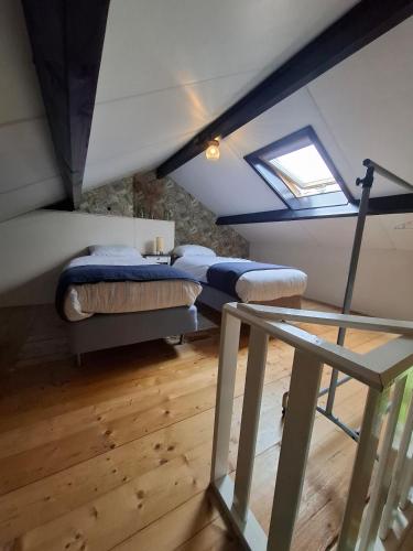 a attic room with two beds and a window at Fully equipped private guesthouse for up to 4 guests, quiet countryside location, only 30 minutes from Rotterdam, free parking, WiFi and large garden in Klaaswaal