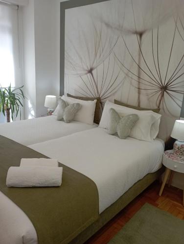 a bedroom with two beds with white pillows at Súper apartamento Santiago in Santiago de Compostela