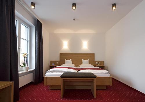 a bedroom with a bed with a red carpet at Gasthof Diem in Krumbach