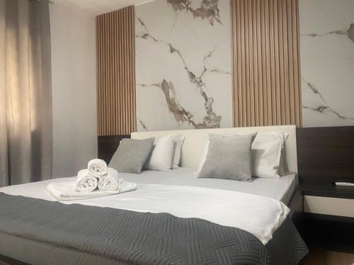 a bedroom with a bed with two towels on it at New Apartments Blue in Ulcinj