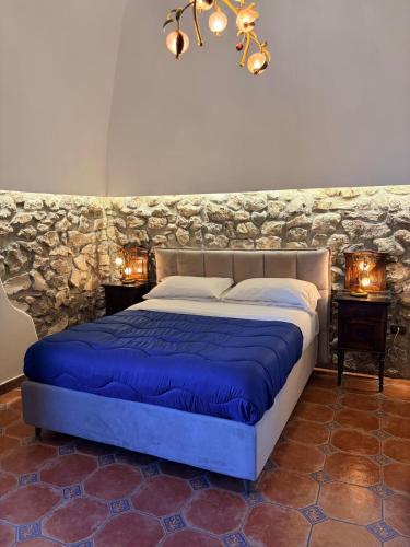 a bed in a room with a stone wall at Villa Denise in Vico Equense