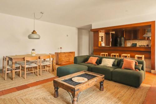 a living room with a green couch and a table at Quinta de Travanca - Casa da Eira in Baião