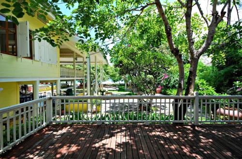 a porch with a white fence and a tree at Baan Bayan - Hua Hin - SHA Extra Plus in Hua Hin