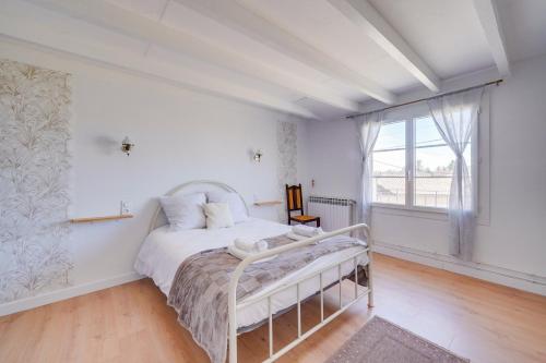 a bedroom with a white bed and a window at Maison de charme à st émilion in Saint-Émilion