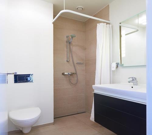 a bathroom with a toilet and a sink and a shower at Best Western Plus Hotel Fredericia in Fredericia