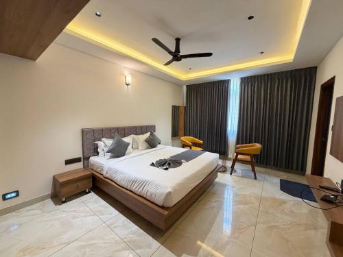 a bedroom with a bed with a ceiling fan at Hotel Grand Central Mysore in Mysore