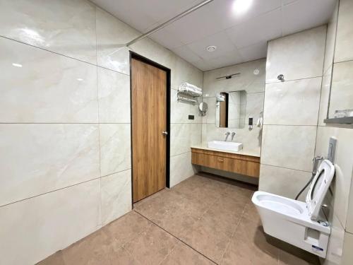 a bathroom with a toilet and a sink and a mirror at Hotel Grand Central Mysore in Mysore