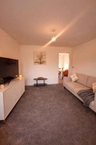 a living room with a couch and a flat screen tv at Bright & Spacious 3-Bed Rotherham Home Ideal for Families or Contractors in Kimberworth