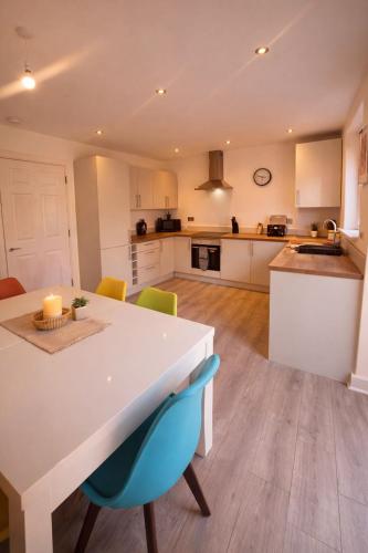 a kitchen with a white table and some chairs at Bright & Spacious 3-Bed Rotherham Home Ideal for Families or Contractors in Kimberworth