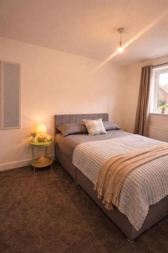 a bedroom with a bed and a window at Bright & Spacious 3-Bed Rotherham Home Ideal for Families or Contractors in Kimberworth