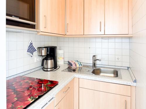 a kitchen with a sink and a counter top at Haus Ausreißer 2 - Ankerplatz in Bensersiel