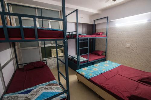 a room with three bunk beds in a dorm at Vrindavan Bunk Hostel by Shiva - 5min Walk from Prem Mandir in Vrindāvan