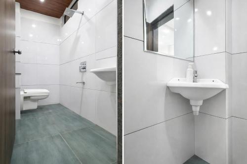 a white bathroom with a sink and a toilet at FabHotel Rama in Indore