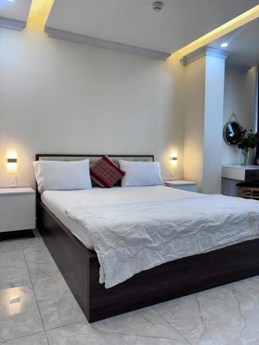 a bedroom with a large bed with white sheets and pillows at Sao Việt Nam Hotel in Ho Chi Minh City