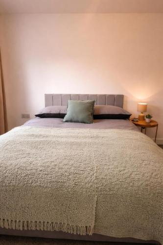 a bedroom with a large bed with a blue pillow at New Build 3-Bed in Rotherham Fast WiFi, Garden & Driveway in Kimberworth
