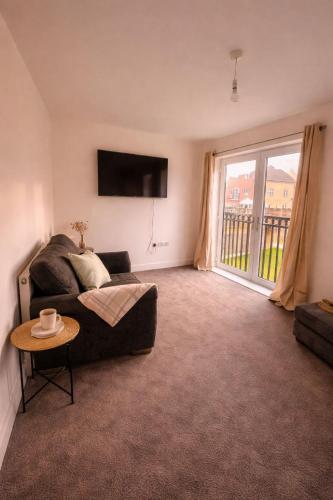 a living room with a couch and a large window at New Build 3-Bed in Rotherham Fast WiFi, Garden & Driveway in Kimberworth