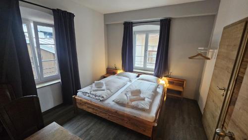 a bedroom with a bed and two windows at Endorfer Stubn in Bad Endorf