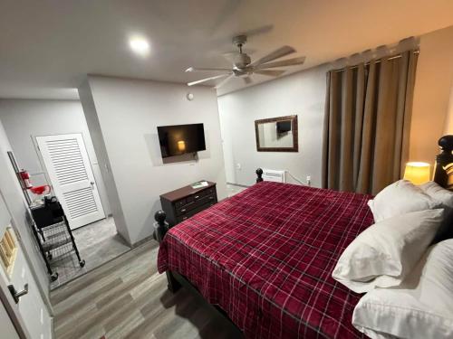 a bedroom with a bed with a red plaid blanket at Germantown Inn & Lounge in Hermann