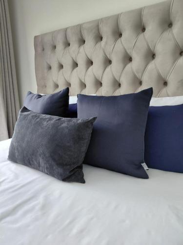 a bed with four pillows on a bed with a headboard at Royal Golfview Stay in Boksburg