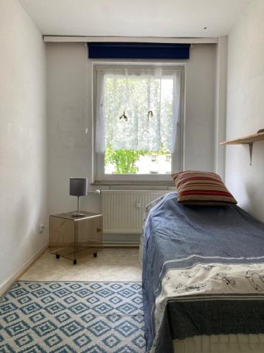 a bedroom with a bed and a window at Self check in ganzes Apartment 40 m zwei Schlafzimmer Wlan Parkplatz eigenes Badezimmer mit Badewanne Kochecke Einfamilienhaus in Duisburg
