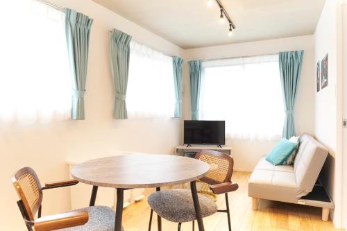 a living room with a table and chairs and a couch at Frontier Comfort Kitaikebukuro by Tranova in Tokyo