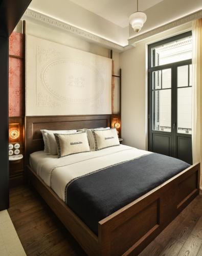 a bedroom with a large bed and a window at Ergon House Ermou in Athens
